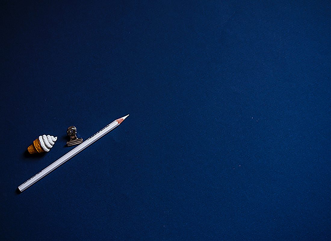 A single pencil on a deep blue surface